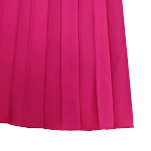 Détail d'une combinaison plissée fuchsia montrant la couture et la texture du tissu