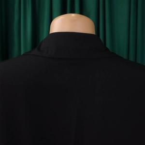 Detail view of smooth tailoring on the back shoulder of a black elegant blazer