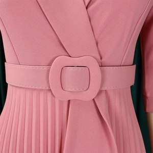 Détail d'une robe plissée rose poudré avec encolure croisée et ceinture à la taille