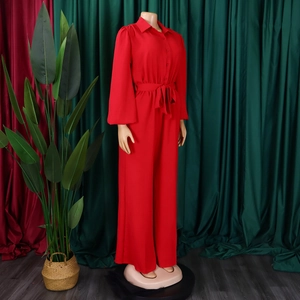 Detail of red long-sleeved jumpsuit featuring a shirt collar and adjustable waist tie