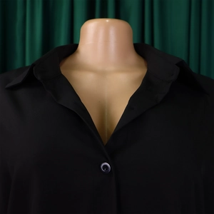 Detailed view of black shirt collar with button and V-neckline on a female mannequin