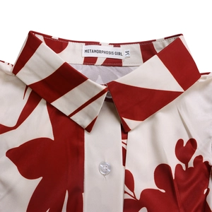 Détail du col de chemise à imprimé floral rouge et blanc avec étiquette et bouton