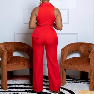 Detail view of the elegant asymmetrical peplum waist on a red sleeveless jumpsuit back