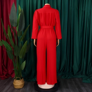 Back view of high-waist red wide-leg jumpsuit featuring long sleeves and waist belt detail