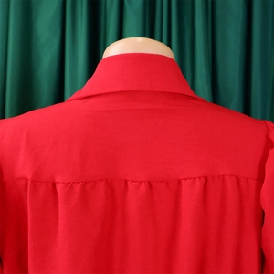 Detail view of red jumpsuit neckline with fine pleats and high-quality cotton fabric