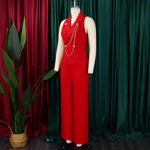 Detail view of red sleeveless blazer suit with gold chain and matching wide-leg trousers