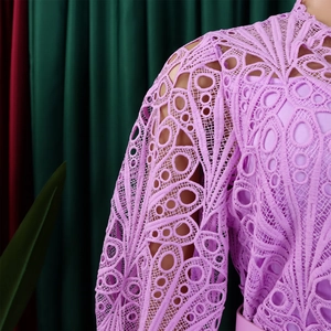 Detailed close-up of light purple lace dress featuring hollow-out floral patterns and puff sleeves
