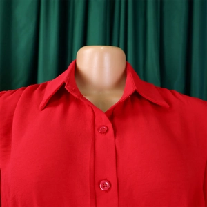 Close-up detail of the red long sleeve jumpsuit lapel collar and button closure