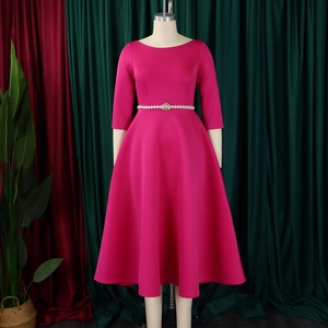 Macro detail of magenta A-line evening dress featuring a pearl embellished waist belt