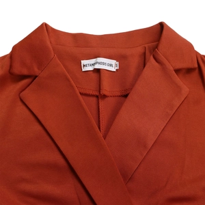 Detail eines rostroten Jumpsuit-Kragens mit Metamorphosis Girl-Label und Größe M