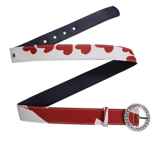Détail d'une ceinture tendance à motifs cœurs rouges et blancs et boucle ronde en strass