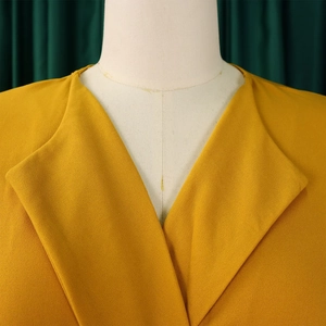 Gros plan du col à revers jaune gingembre sur une robe tissée élégante pour le bureau