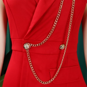 Detail view of red sleeveless jumpsuit with gold chain accents and embossed buttons