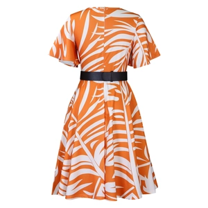 Détail d'une robe midi d'été évasée avec imprimé palmier orange et fine ceinture noire