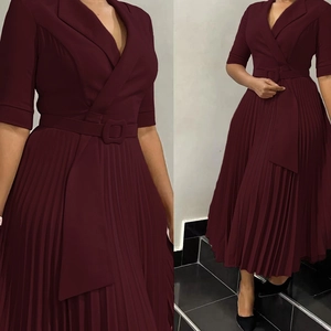 Détail de la robe rouge bordeaux à col en V avec jupe plissée et ceinture assortie chic