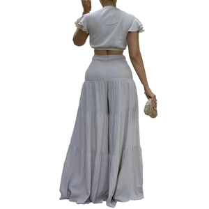 Détail de la taille haute smockée et du pantalon large à volants en lin