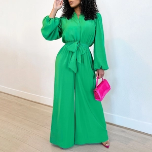 Detail of vivid green wide-leg jumpsuit with long lantern sleeves and tie-waist