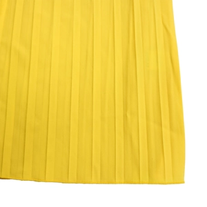 Vue détaillée du tissu plissé jaune vif avec coutures fines et plis verticaux réguliers