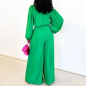 Detail view of the green wide-leg jumpsuit showing long puff sleeves and back silhouette