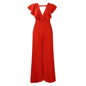 Détail d'une combinaison rouge à col en V profond avec pantalon plissé et taille smockée