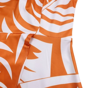 Détail macro de la robe à taille haute avec imprimé feuilles tropicales orange et coutures