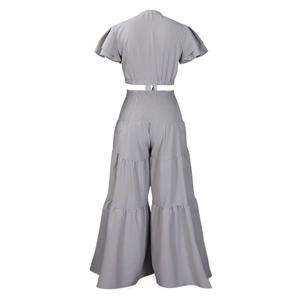 Détails d'un ensemble gris deux pièces avec manches volantées et pantalon large à étages