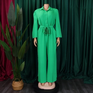 Detail of green long-sleeve jumpsuit featuring shirt collar and adjustable waist tie