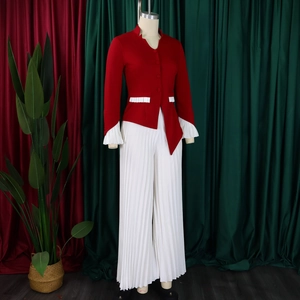 Detail view of burgundy asymmetrical top with flare sleeves and white pleated wide leg pants