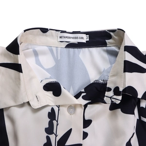 Détail du col à revers et d'un bouton sur une chemise imprimée florale noire et blanche