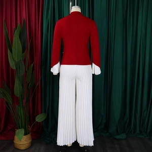Rear view of red flared sleeve top and white pleated wide-leg pants on mannequin