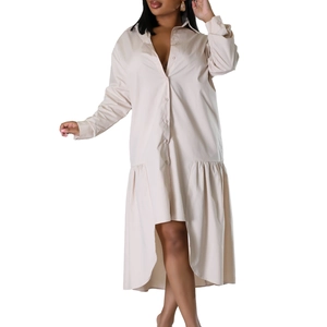 Detail of loose beige shirt dress featuring button-up front and irregular high-low hemline