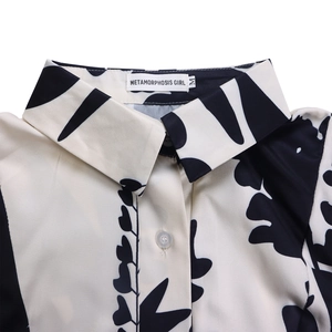 Détail du col à revers et des boutons sur robe à imprimé abstrait avec étiquette M