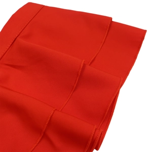 Détail macro du tissu rouge superposé avec coutures précises sur cette combinaison chic