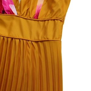 Dettaglio dell'abito con scollo a V in tessuto plissettato giallo senape e fiori stampati