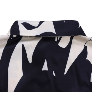 Détail du col à revers élégant sur une chemise à motif abstrait noir et blanc