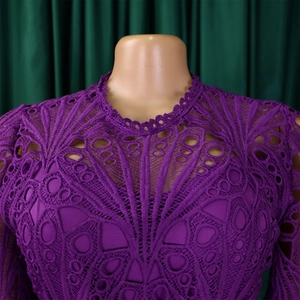 Detail of purple lace dress neckline showing intricate hollow-out patterns and inner lining