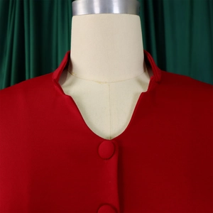 Close-up of red top with unique stand collar, fabric buttons and pleated texture