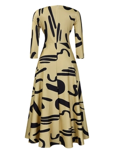 Detail view of the back of a khaki A-line dress with black abstract print and hidden zipper