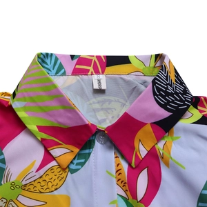Détail d'un col de chemise imprimé avec revers et fermeture par bouton transparent