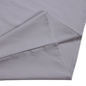 Détail de la double couture et du surjet sur le tissu gris du pantalon large