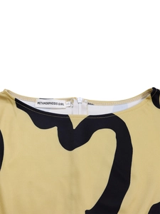 Close-up of elegant cream dress neckline with black abstract prints and white zipper detail