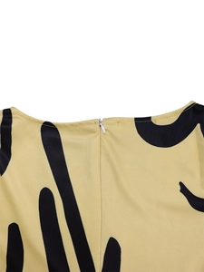 Detail of invisible white zipper and mustard yellow printed fabric on elegant dress