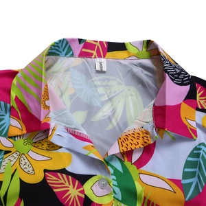 Détail du col et des boutons de la chemise avec un imprimé floral tropical vibrant