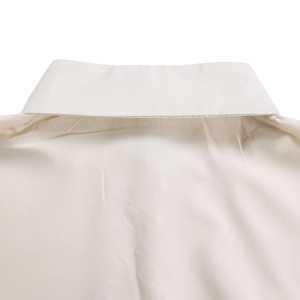Detail of the high-quality pointed collar and fine stitching on the beige cotton dress shirt