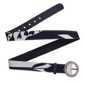 Détail d'une ceinture imprimée dotée d'une grande boucle ronde sertie de strass brillants