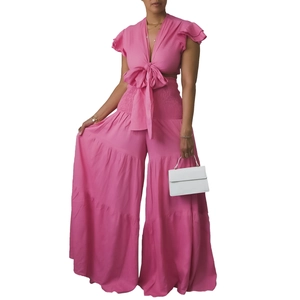 Détail d'un ensemble rose deux pièces avec haut court à nœud et pantalon large à volants