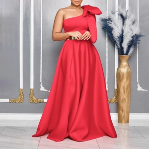 Detail of red one-shoulder evening gown featuring oversized bow and gold metallic belt