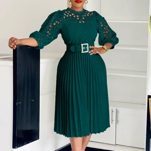 Detail of elegant dark green dress featuring hollow out lace bodice and pleated skirt texture