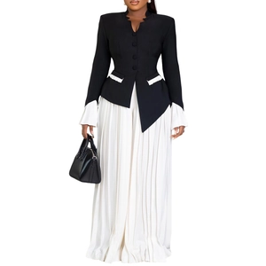 Detail view of the black blazer with pleated sleeve cuffs and a white pleated maxi skirt