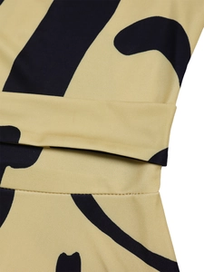 Detail of waist belt and abstract black print on ginger yellow fabric of the dress